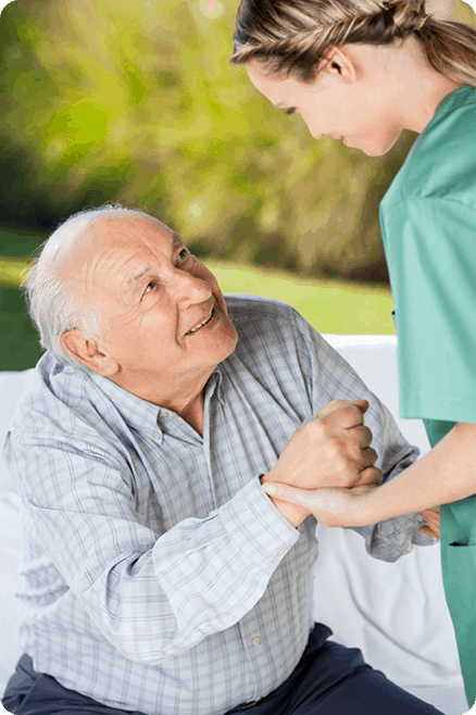 A nurse is helping an elderly man on a bed.