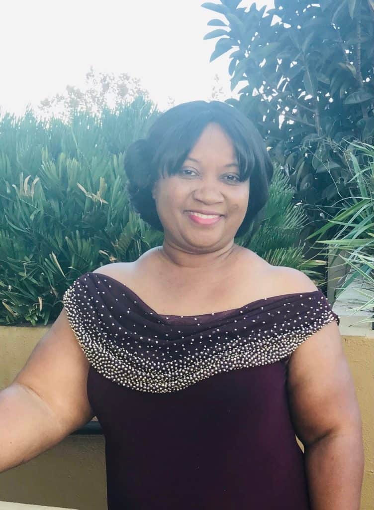 A woman in a burgundy dress posing for a photo.